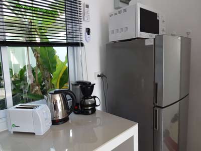 Kitchen worktop with window on garden, two door refrigerator 